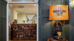 A reception area with a sign labeled 'Reception' and a wall of stacked luggage.