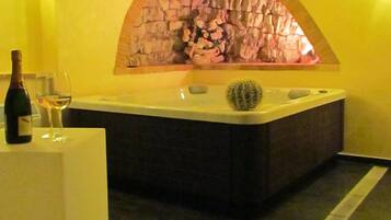 Relax in a spacious bathtub, surrounded by a unique arched wall and a small cactus plant.