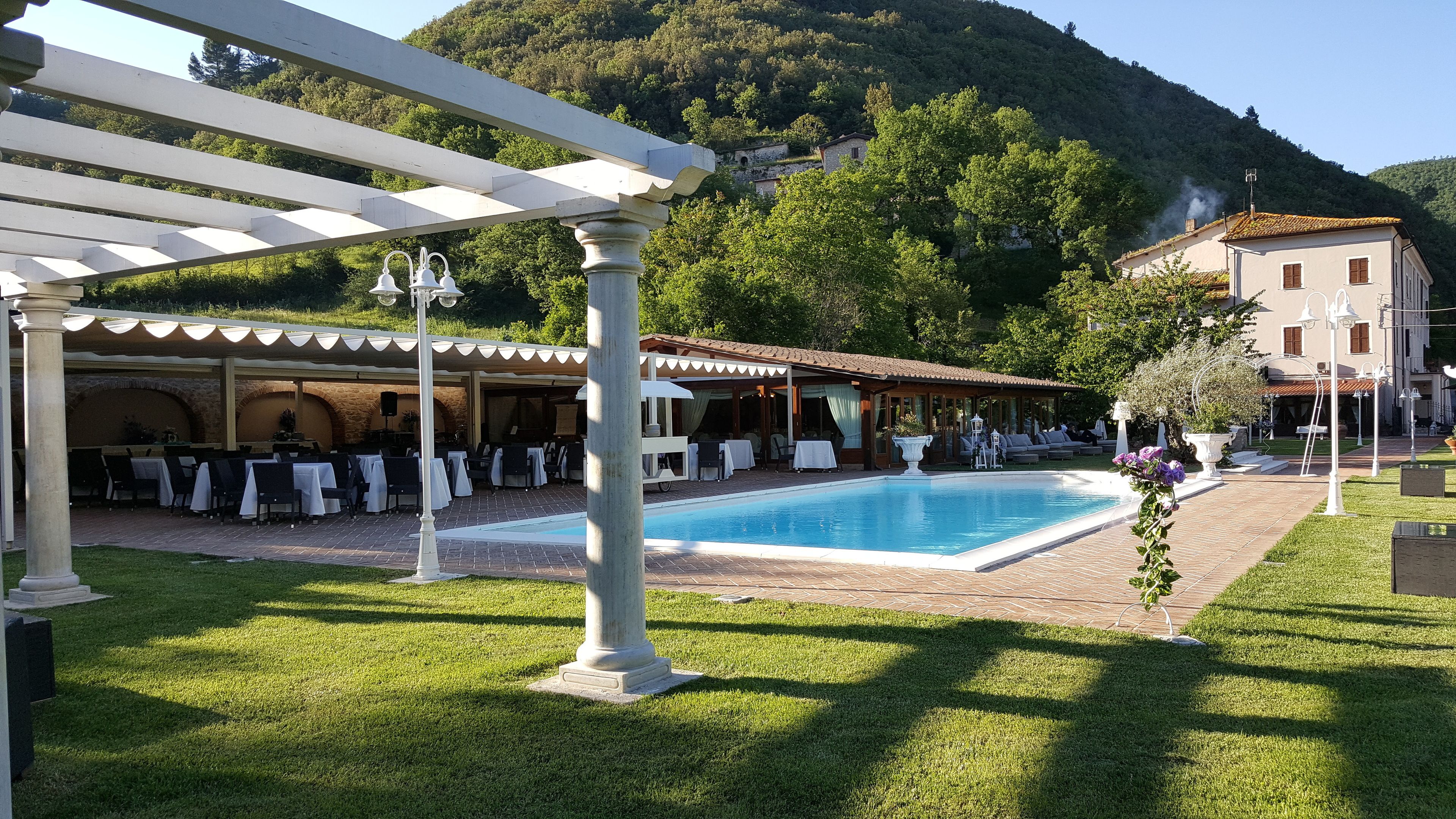 A poolside area with outdoor seating and a pergola.