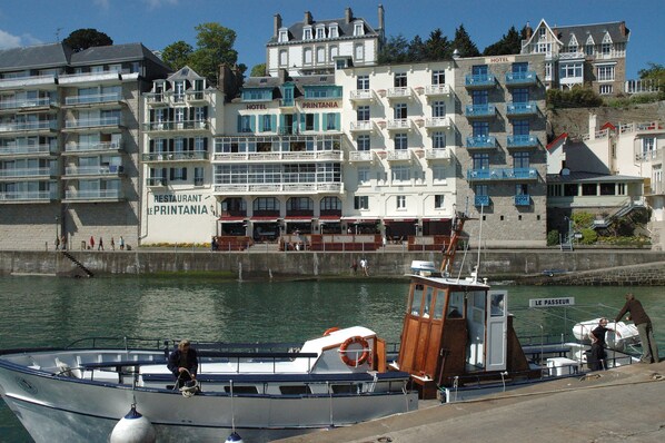 Un hotel frente al agua con varios balcones y un letrero que dice "RESTAURANT LE PRINTANIA".
