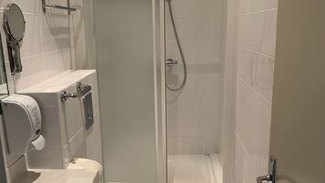 Une salle de bain moderne équipée de toilettes, d’un bidet et d’une douche.
