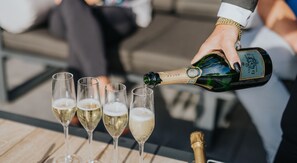 A person pouring champagne into glasses on a wooden table. - Hotel, Sportsbar & Brasserie Dorhout Mees (Biddinghuizen)