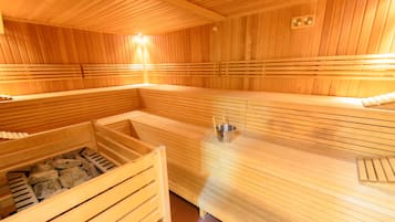A wooden sauna with benches and a stone-filled bench area.