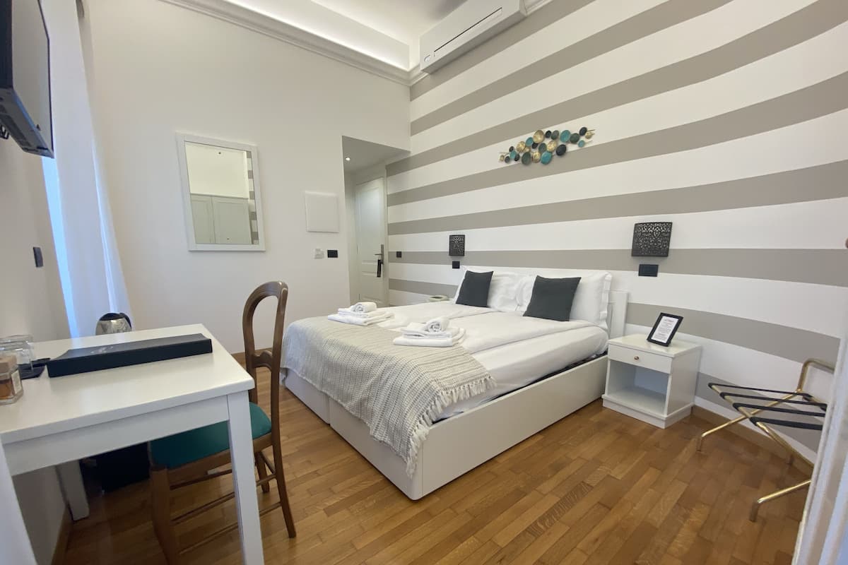 Una camera da letto moderna con un letto grande, comodini, una scrivania e una sedia.
