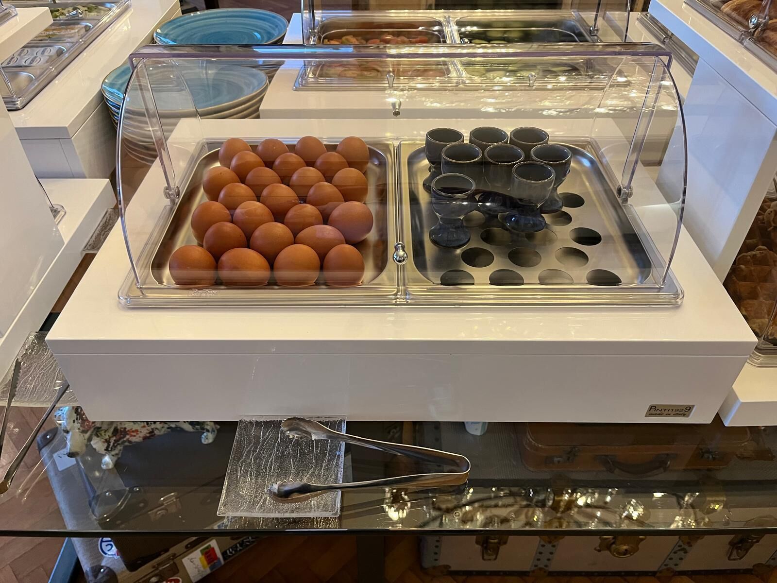 Un buffet avec des plateaux d’œufs et des carafes de boissons.