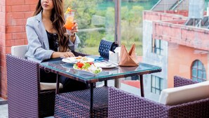Una persona cenando en una mesa al aire libre con vistas a un paisaje montañoso.