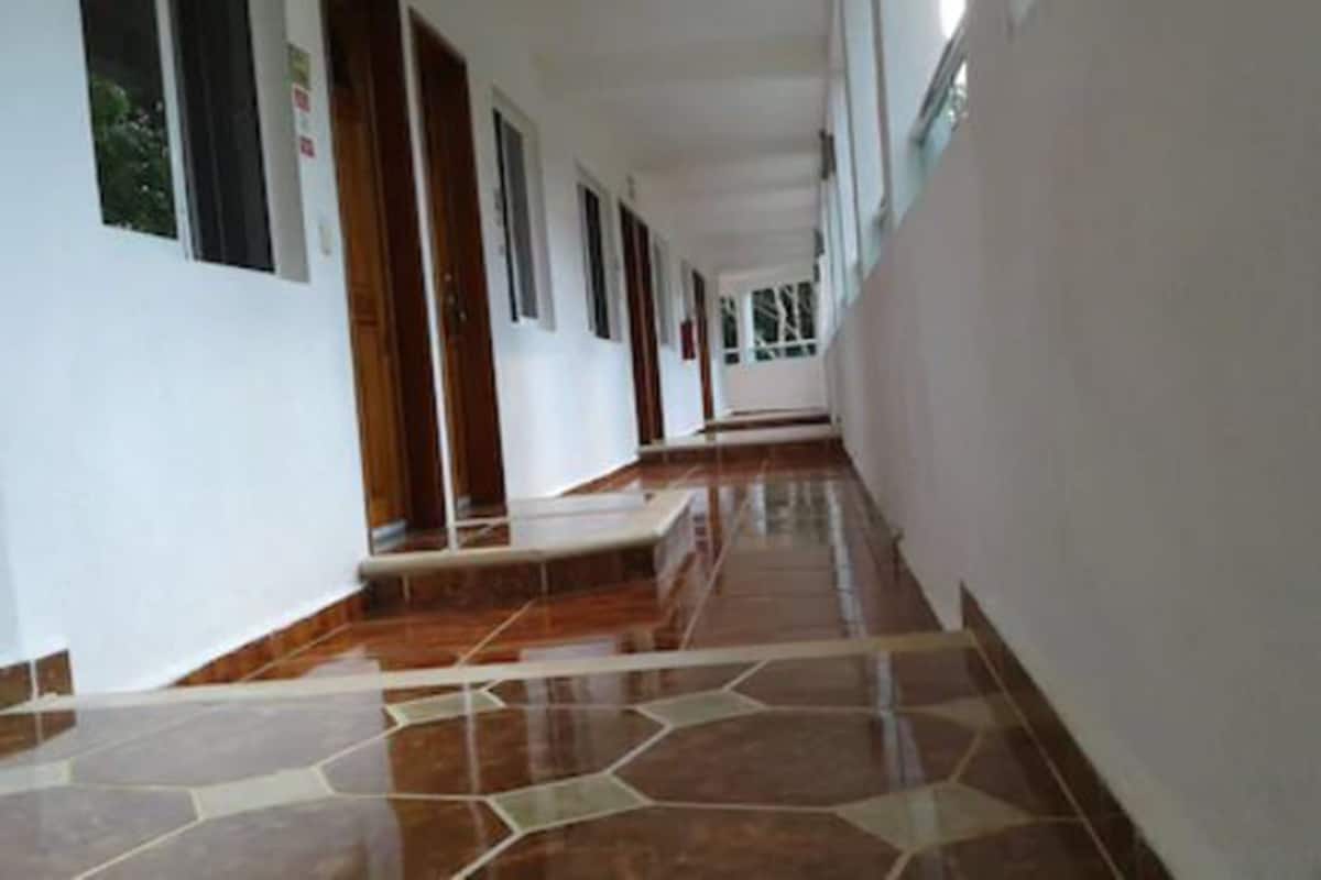 Un pasillo con piso de baldosas y paredes blancas.