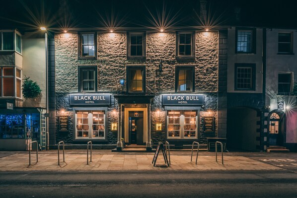 A building with two signs reading "Black Bull Hotel" and a sign for "National Food Rooms Garden". - The Black Bull Hotel (Kirkby Stephen)