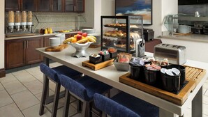A breakfast bar with various food items, a coffee station, and a toaster. - Hilton Garden Inn Bossier City, LA (Bossier City)