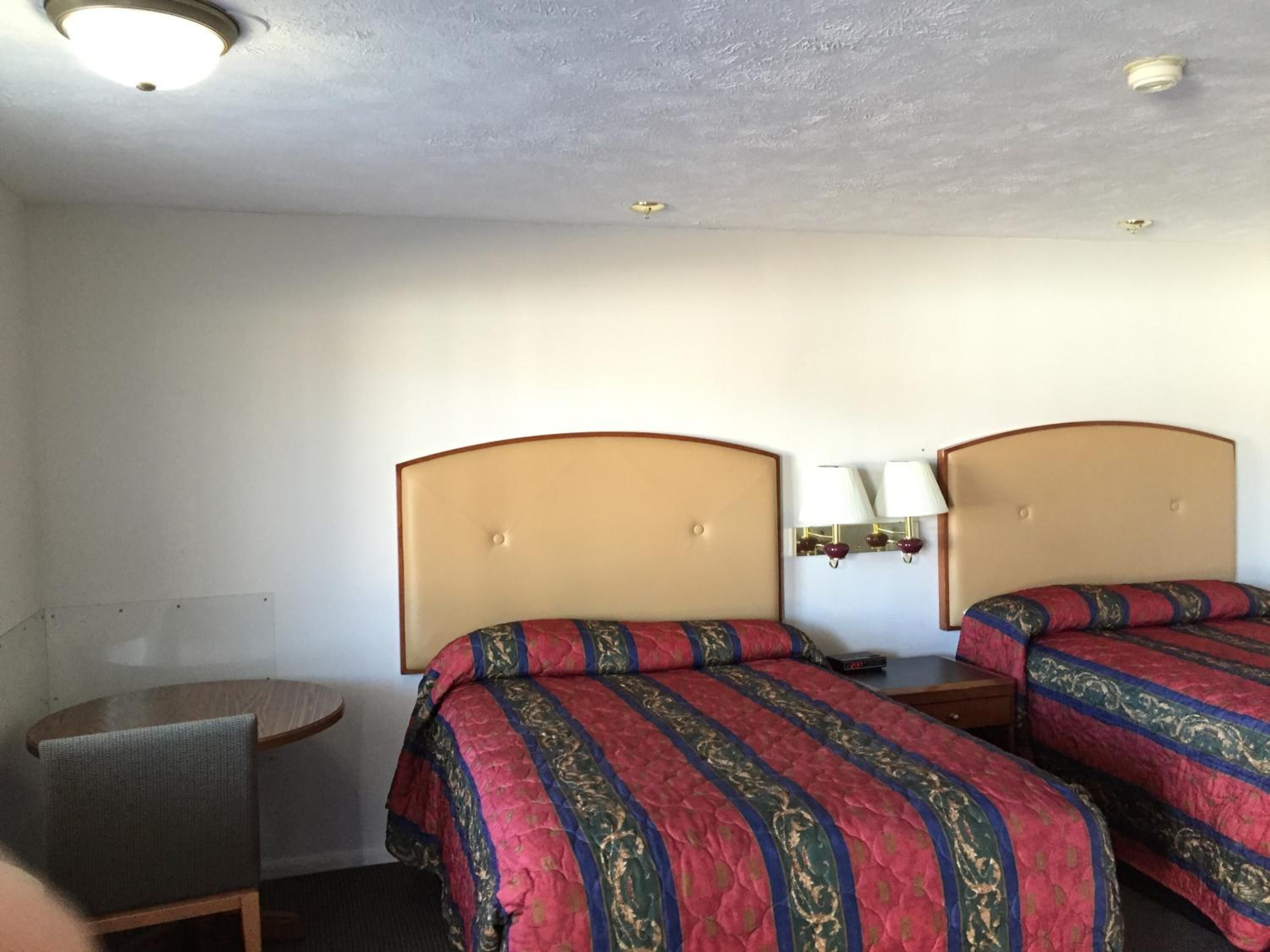 Une chambre d’hôtel avec deux lits, une petite table et une chaise.