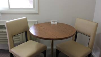 Habitación para no fumadores con una mesa de madera redonda y dos sillas color beige.