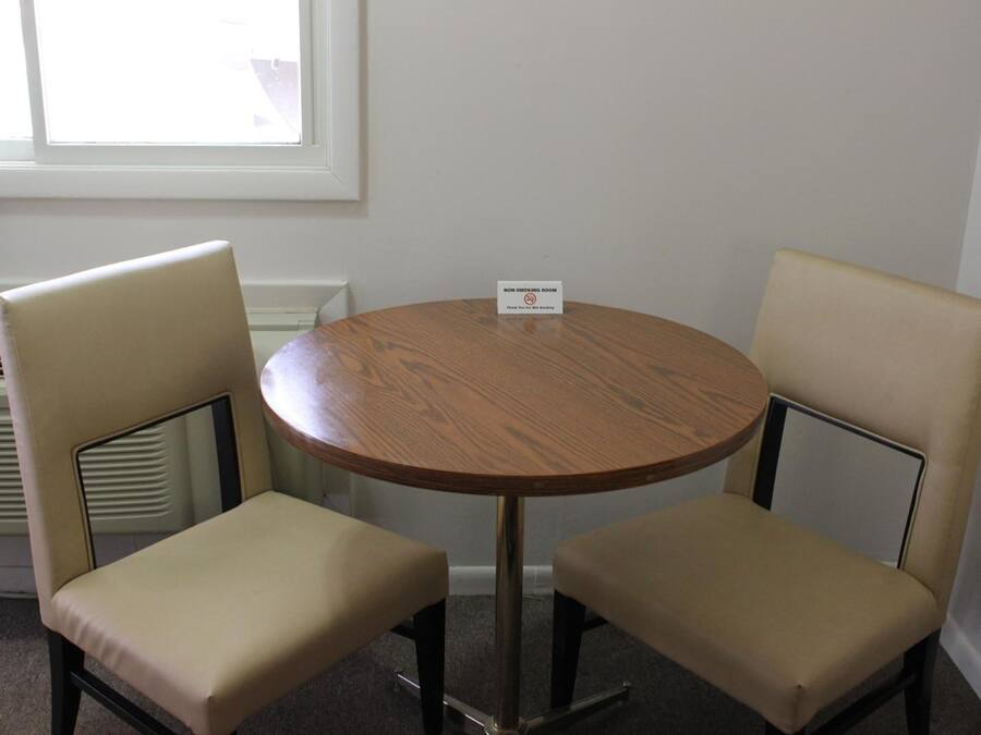A non-smoking room with a round wooden table and two beige chairs.