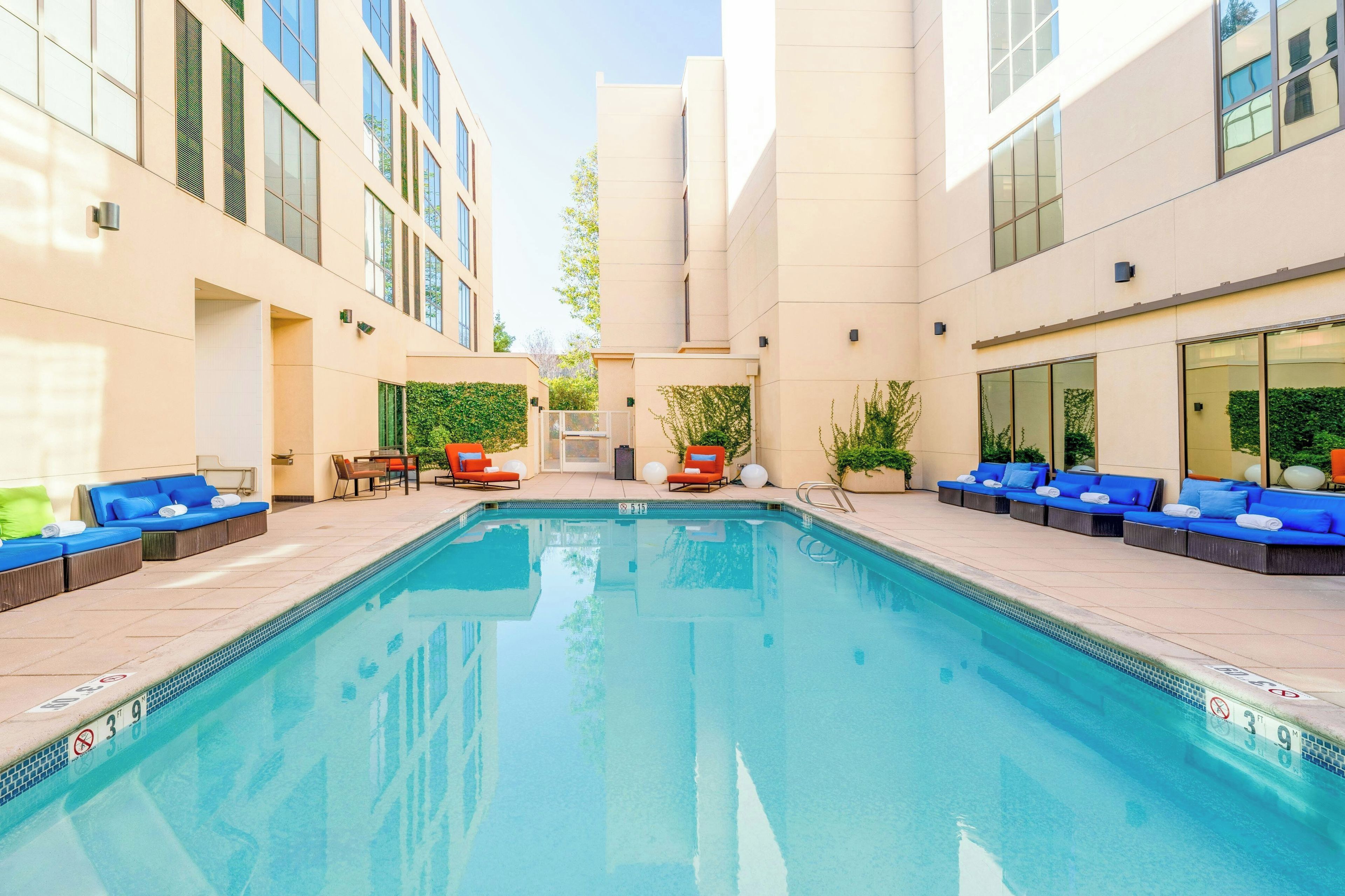 A swimming pool with lounge chairs and a covered area.
