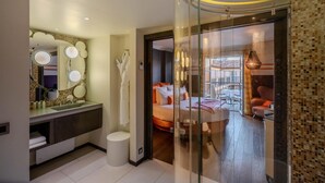 A modern bathroom with a large mirror, a vanity, and a glass shower enclosure.