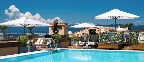 Piscine extérieure, parasols de plage, chaises longues