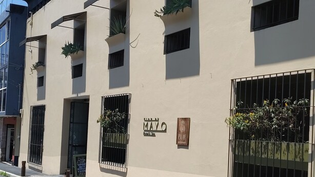A building with multiple balconies, some with plants, and a sign indicating 'MAYO' and 'BLUE'. - Flor de Mayo Hotel & Restaurant - Adults only (Cuernavaca)