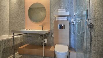 A modern bathroom with a freestanding sink, a toilet, and a glass-enclosed shower area.