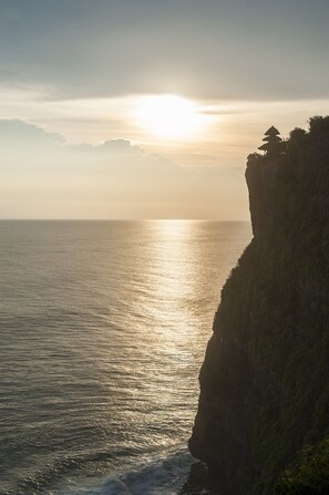 Un paysage côtier avec une falaise et l’océan.