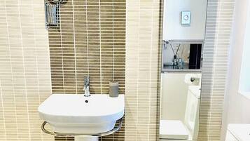 A bathroom with a white sink, a toilet, and a mirror.