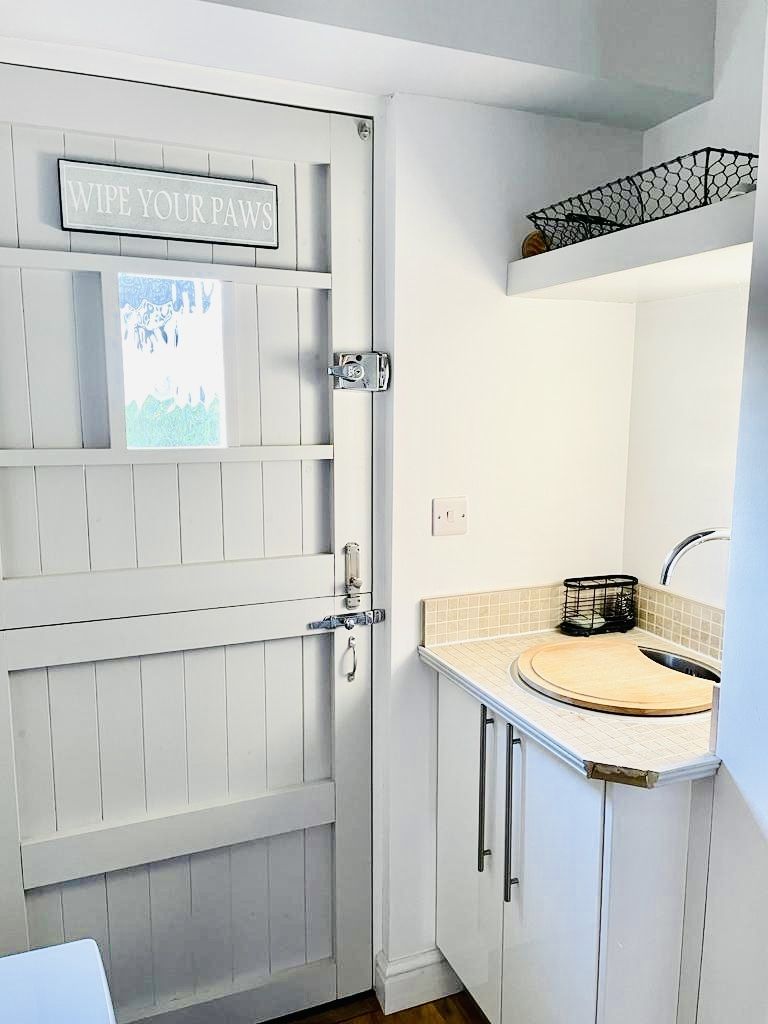 A bathroom with a white door, a sink, and a towel rack.