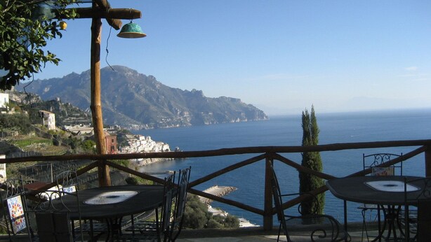 A terrace with outdoor seating overlooking a coastal view, including a mountain and the sea. - Villa Rina (Amalfi)