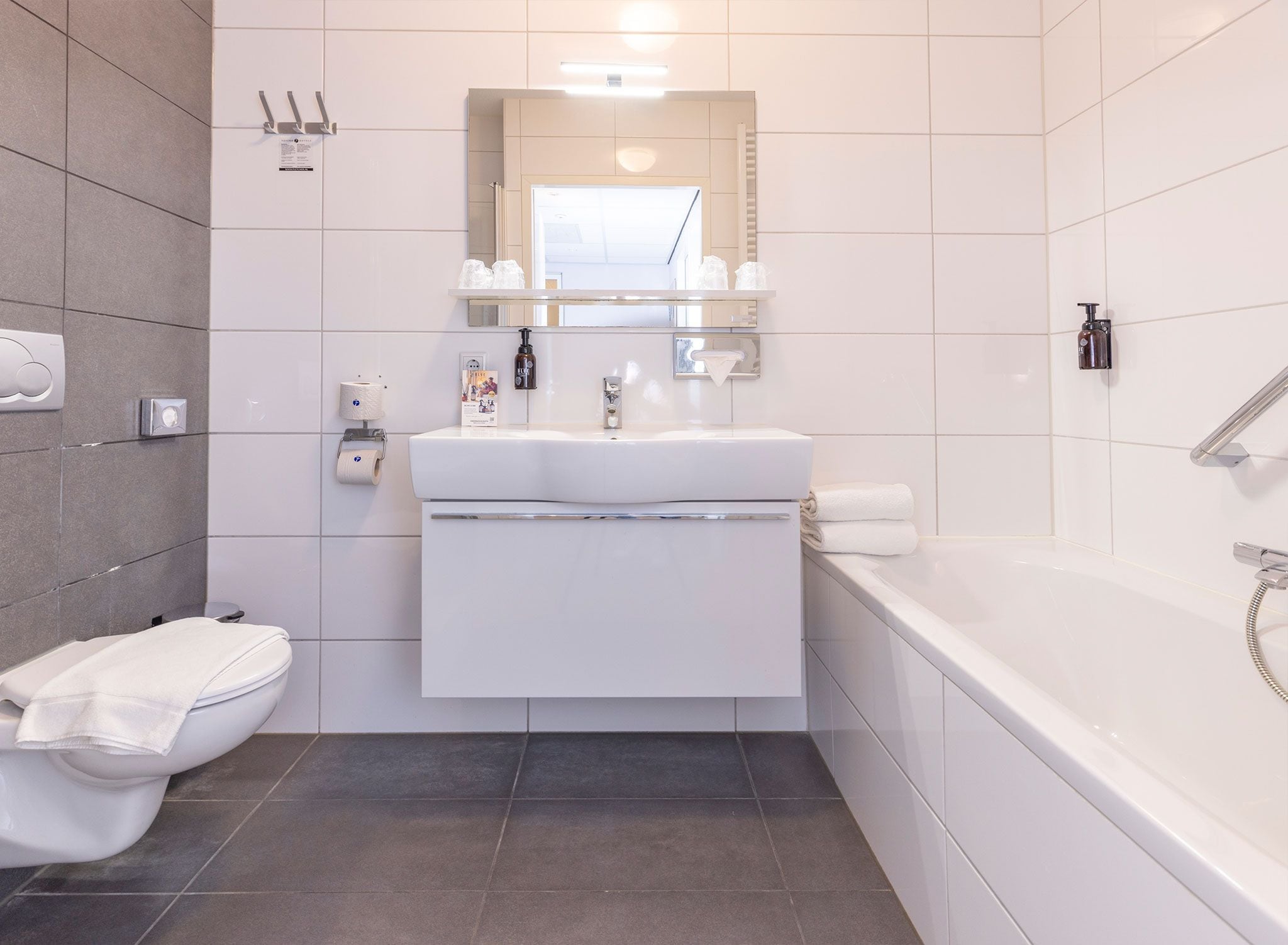 A modern bathroom with a toilet, sink, and bathtub.