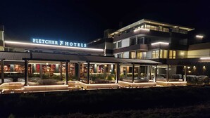 A modern hotel with a lit sign reading "Fletcher Hotels".