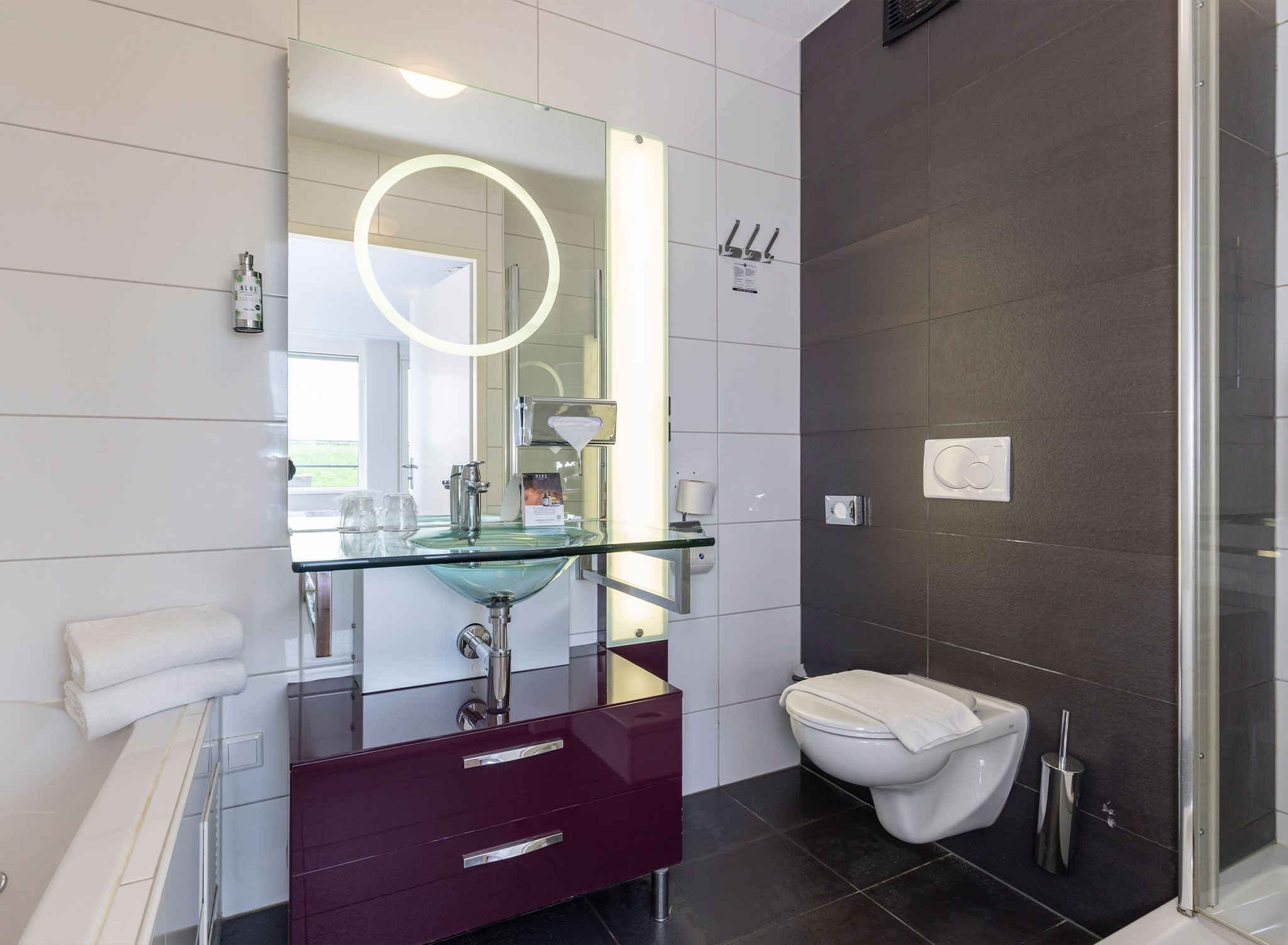 Une salle de bain moderne avec un lavabo en verre, des toilettes et un espace douche.