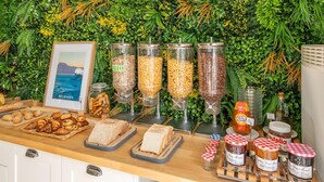 Un bufé con diversos alimentos, incluyendo pan, pasteles y salsas.