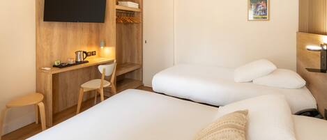 Una habitación de hotel con un escritorio de madera, un televisor, una cama con ropa blanca y una pequeña silla.