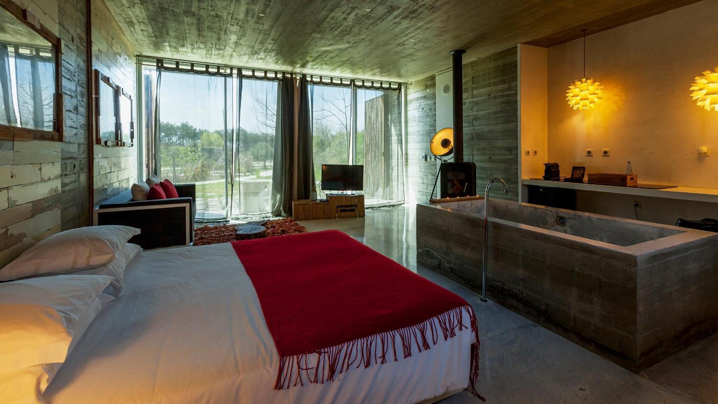 Un dormitorio moderno con una cama grande, televisión y chimenea.