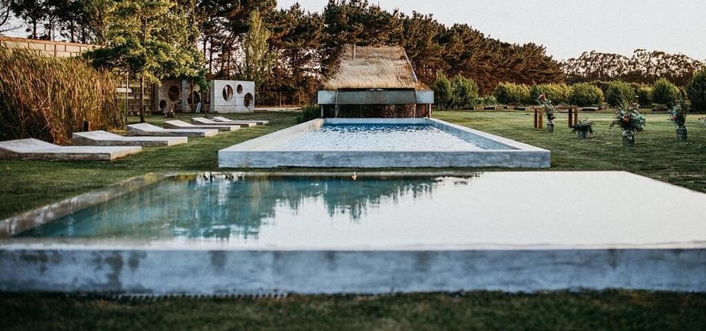 A swimming pool with a thatched roof structure in the background.