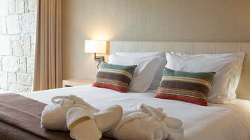A hotel room with a bed, pillows, a nightstand, a lamp, and a towel on the bed.