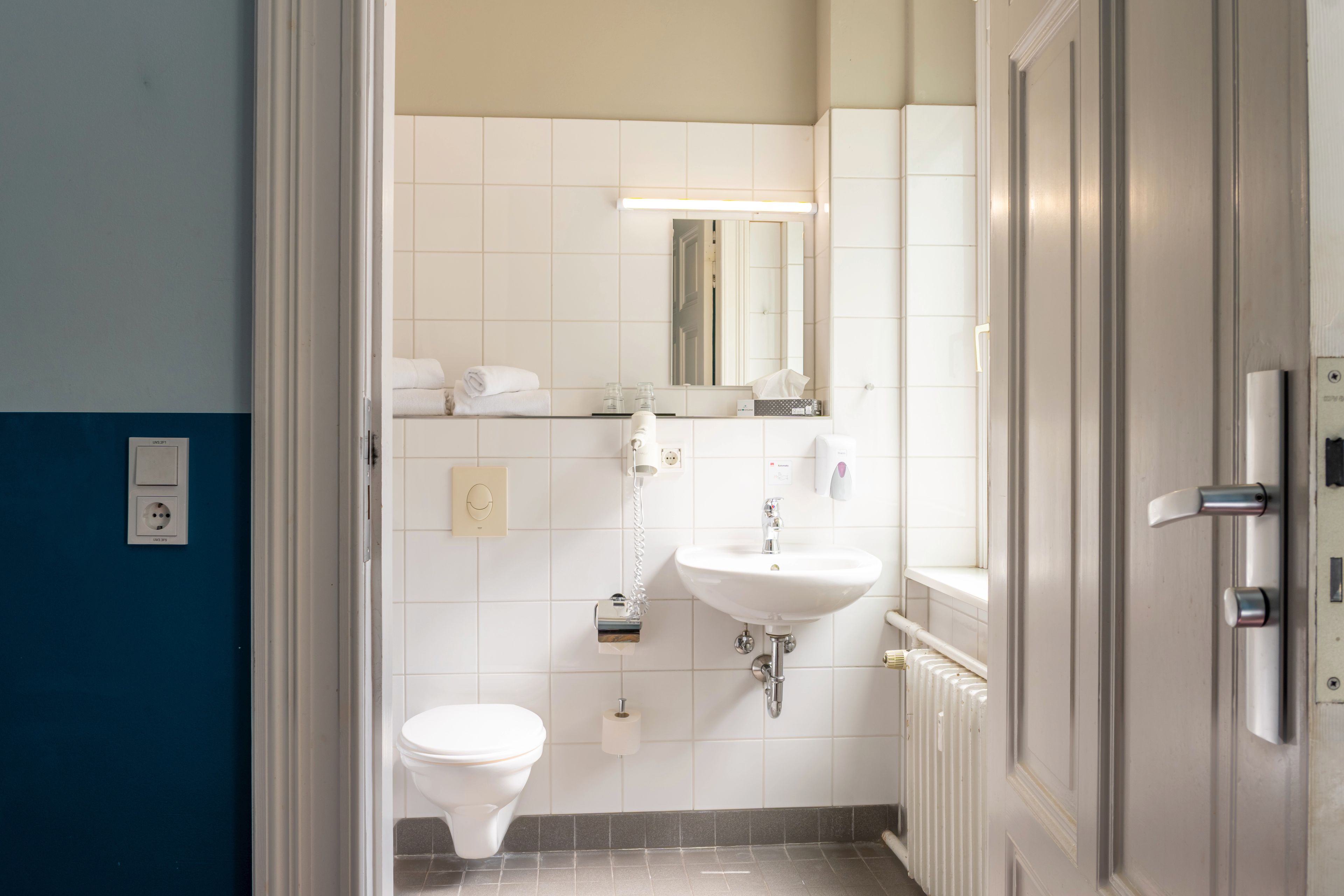Un baño con inodoro, lavamanos y espejo.