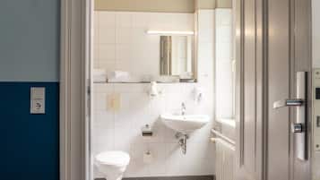 Un baño con inodoro, lavamanos y espejo.
