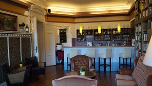 A cozy living room with a bar area, featuring a fireplace, comfortable seating, and a bookshelf. - Grand Hostel Berlin Classic (Berlin)