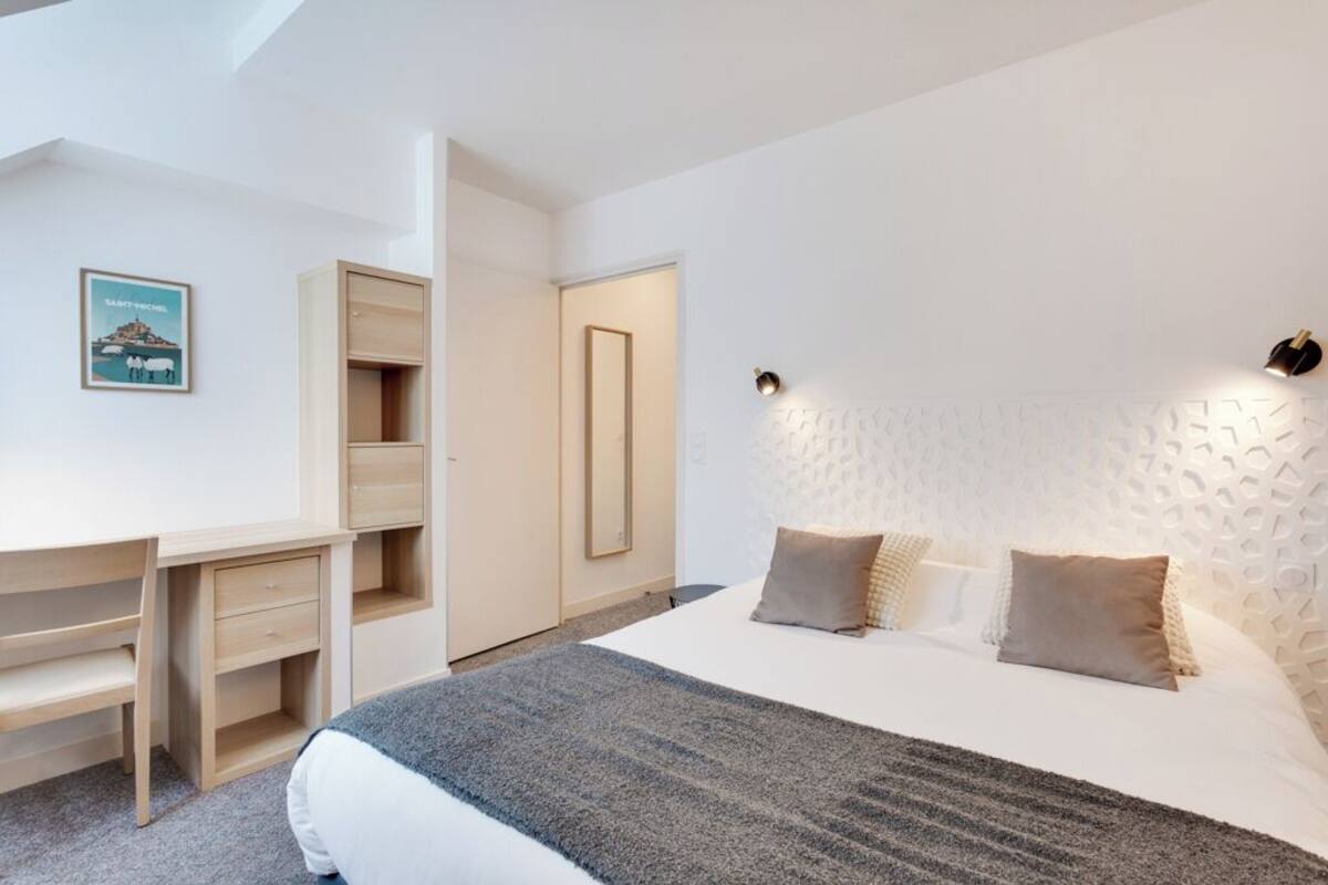 Une chambre moderne avec un lit, un bureau et une armoire.