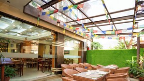 Un restaurant doté d’une terrasse, de murs en verre et de drapeaux aux couleurs vives.