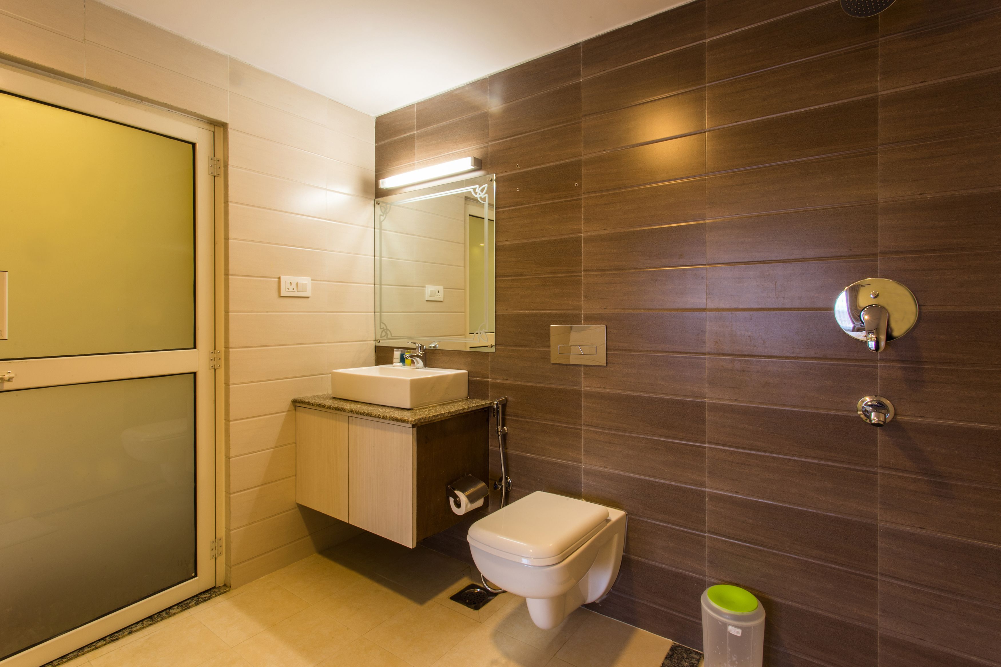 Un baño moderno con inodoro, lavamanos y espejo.