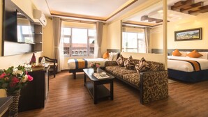 Une chambre d’hôtel avec un canapé, un lit, une télévision et une fenêtre avec des rideaux.