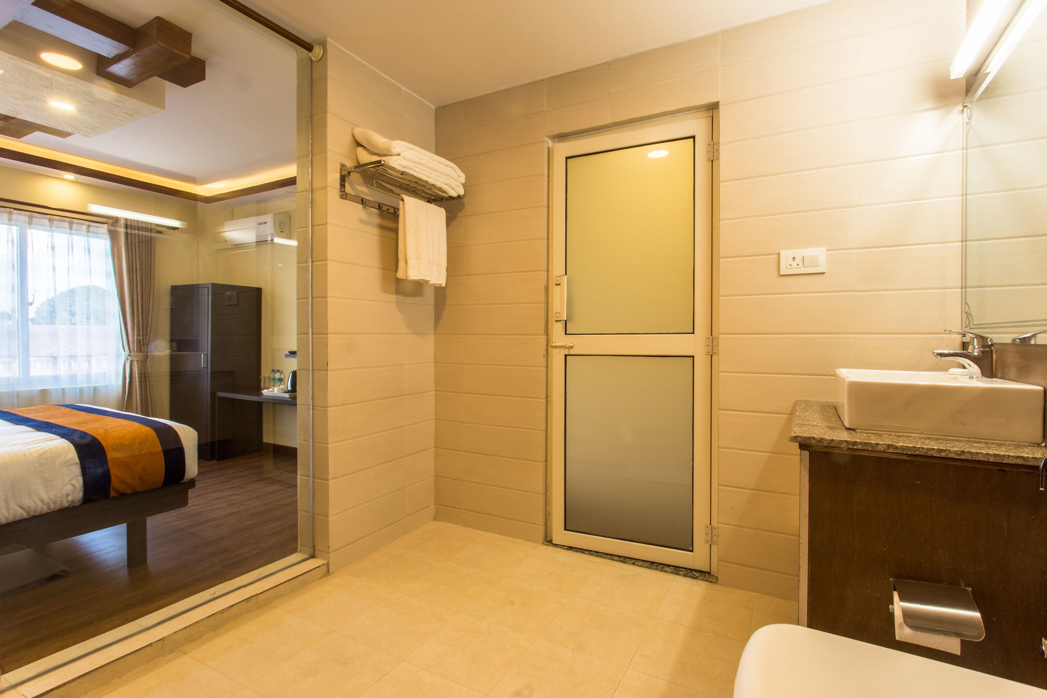 A hotel bathroom with a shower, a sink, and a toilet.