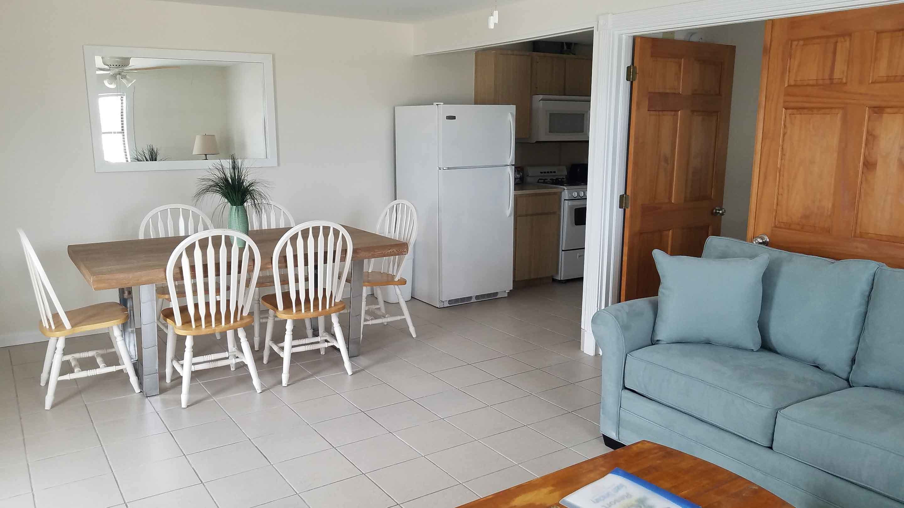 A compact living space with a dining area, kitchenette, and a sofa.