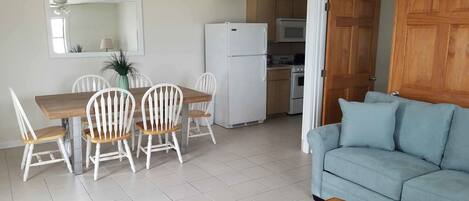A compact living space with a dining area, kitchenette, and a sofa.