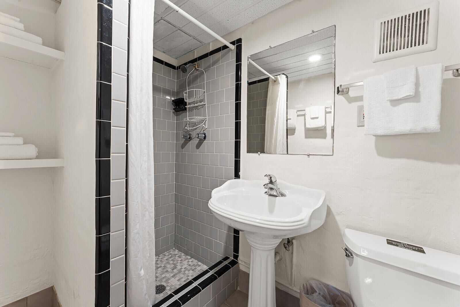 Un bany amb dutxa, un lavabo i un mirall.