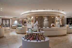 A modern interior with a central counter displaying various products, a person behind the counter, and a well-lit, spacious layout.