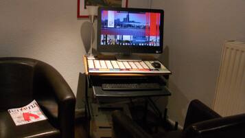 Un espacio de trabajo en casa con escritorio, computadora y dos sillas.