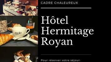 A hotel interior with a breakfast setup including bread, pastries, and a coffee cup labeled 'Folliet'.
