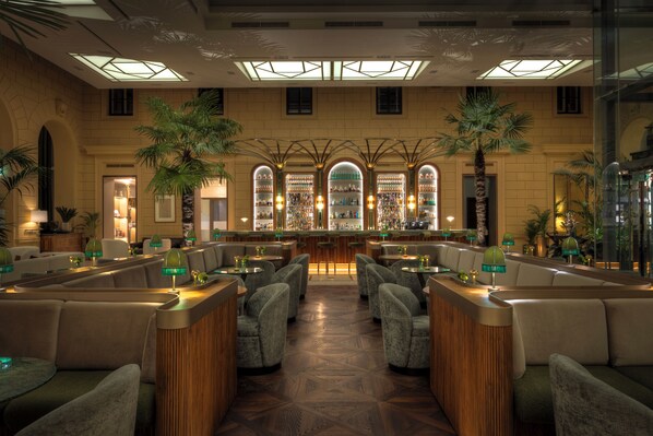 A spacious lobby with a central bar, seating areas, and large windows.