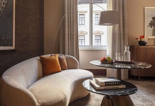 A modern living room with a curved sofa, a round coffee table, and a floor lamp.