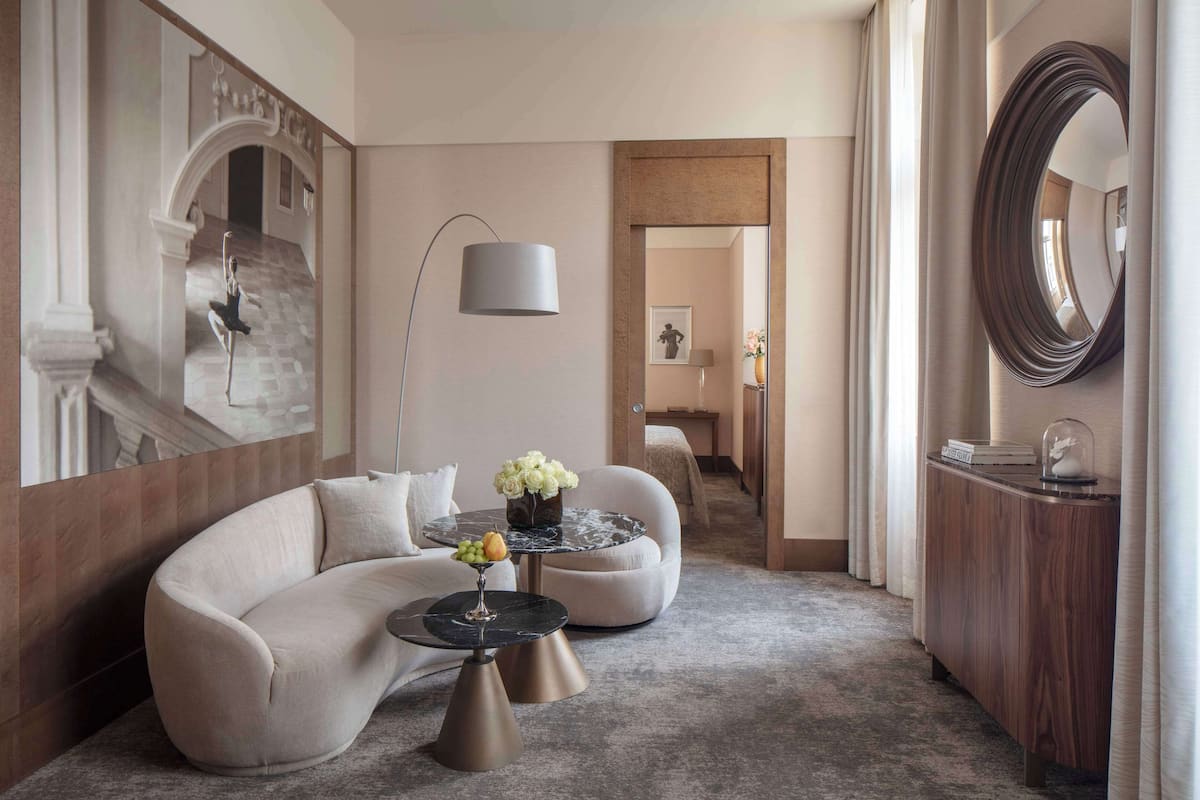 Eine moderne Hotelhalle mit einer gebogenen Couch, einem runden Couchtisch und einer Stehlampe.